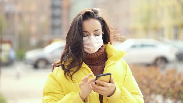 Mujer Con Máscara Seguridad Facial Sosteniendo Smartphone Caminando Por Calle — Vídeos de Stock