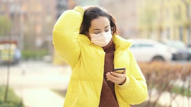 Kvinna Med Skyddande Mask Går Gatan Och Använder Smartphone Långsamma — Stockvideo