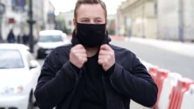 Sokakta yürüyen ve dirseğine hapşıran bir adam..