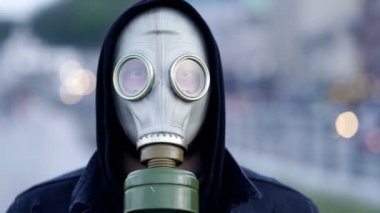 Şehirde gaz maskesi takan yetişkin bir adamın portresi..