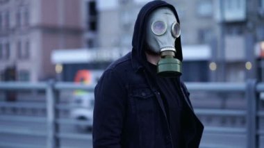 Gaz maskeli bir adam sokakta yürüyor. Yavaş çekim.