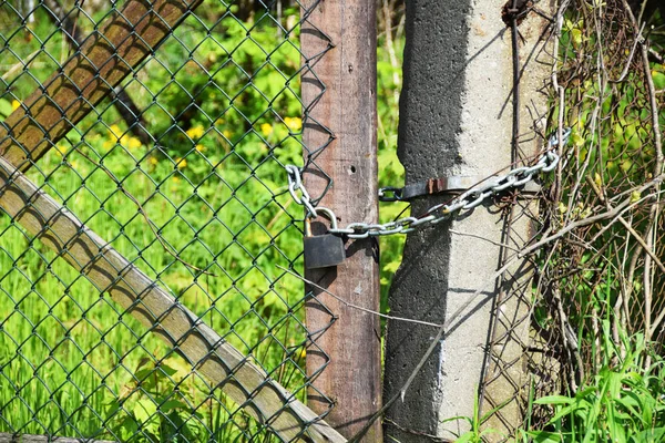 O portão está trancado em um cadeado e uma corrente — Fotografia de Stock