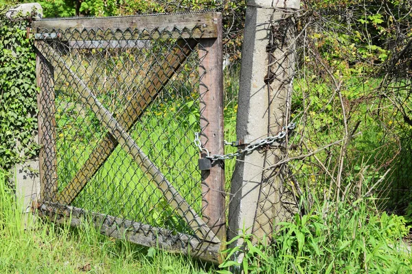 De poort is vergrendeld aan een hangslot en een ketting — Stockfoto