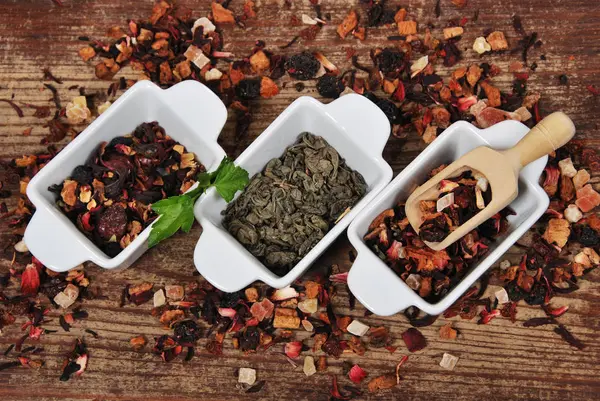 Три керамические белые контейнеры с фруктовым чаем, зеленым чаем, лесом — стоковое фото