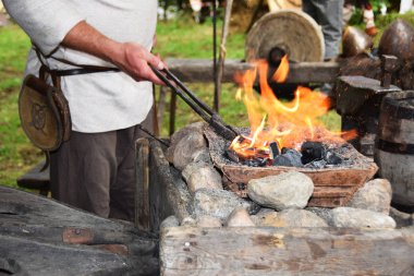 Açık havada bir çekiç ile çalışırken demirci