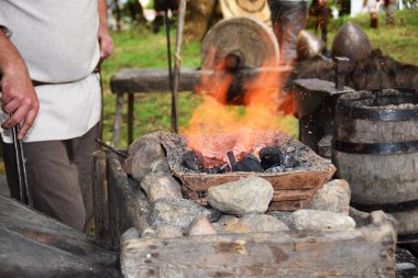 Açık havada bir çekiç ile çalışırken demirci