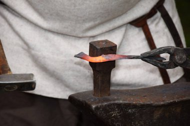 Açık havada bir çekiç ile çalışırken demirci