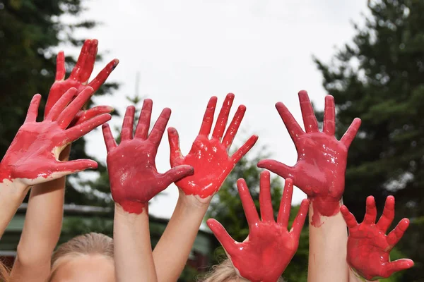 Manos rojas de niños jugando a las manchas — Foto de Stock