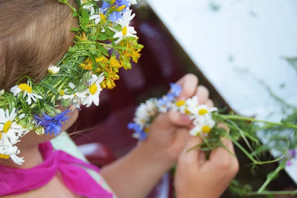 Mani rivestite in una ghirlanda di fiori selvatici da indossare sulla testa — Foto Stock