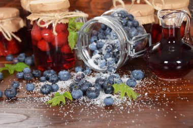 Şeker meyve suyu ile ahşap bir masa üzerinde dağınık çilek