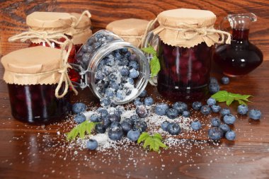 Ahşap bir masa ve bir sürahi meyve suyu dökülmüş şeker çilek