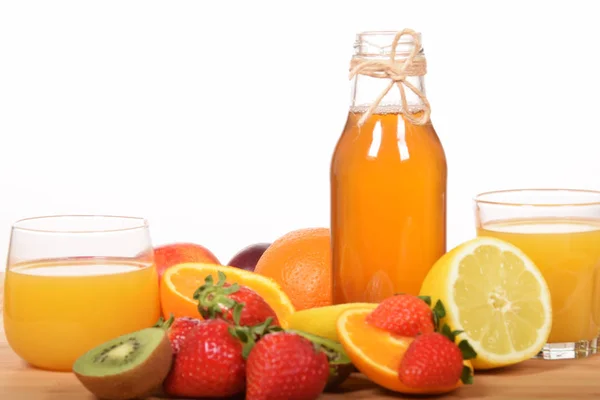 Orangensaft frisch gepresst in Gesellschaft verschiedener Früchte — Stockfoto
