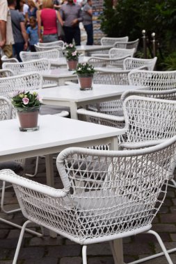 Beyaz hasır sandalye ve masa t önündeki kaldırımda ayarla