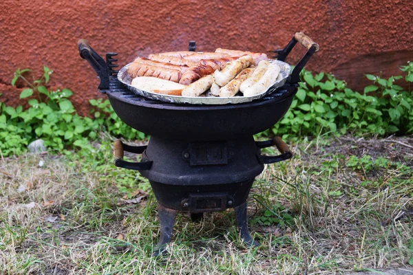 Roasted sausages on an old cast iron grill — Stock Photo, Image