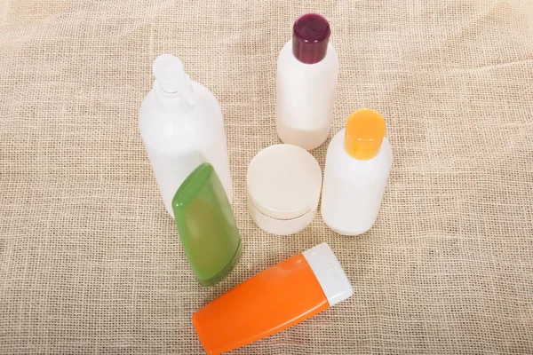 Cosméticos em garrafas de recipientes e tubos de plástico — Fotografia de Stock