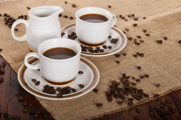Tasses de café et de lait et grains de café torréfiés — Photo