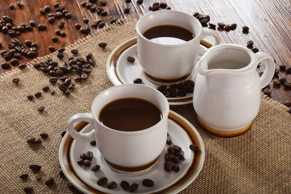 Tazas de café y leche y granos de café tostados — Foto de Stock