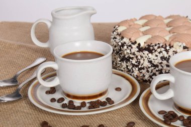 bardak kahve ve süt ve kavrulmuş kahve çekirdekleri