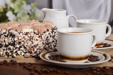 bardak kahve ve süt ve kavrulmuş kahve çekirdekleri