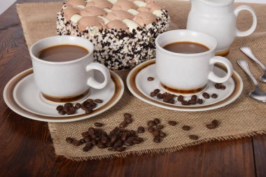 bardak kahve ve süt ve kavrulmuş kahve çekirdekleri