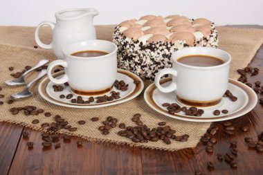 bardak kahve ve süt ve kavrulmuş kahve çekirdekleri