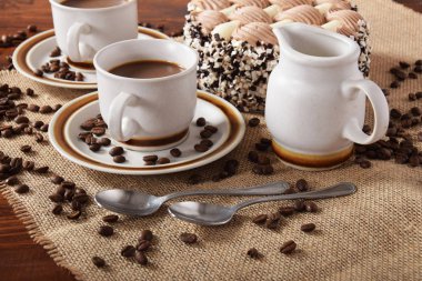 bardak kahve ve süt ve kavrulmuş kahve çekirdekleri