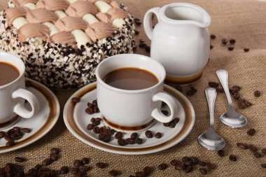 bardak kahve ve süt ve kavrulmuş kahve çekirdekleri