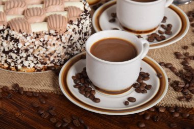 bardak kahve ve süt ve kavrulmuş kahve çekirdekleri