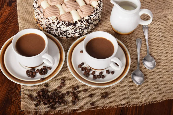 bardak kahve ve süt ve kavrulmuş kahve çekirdekleri