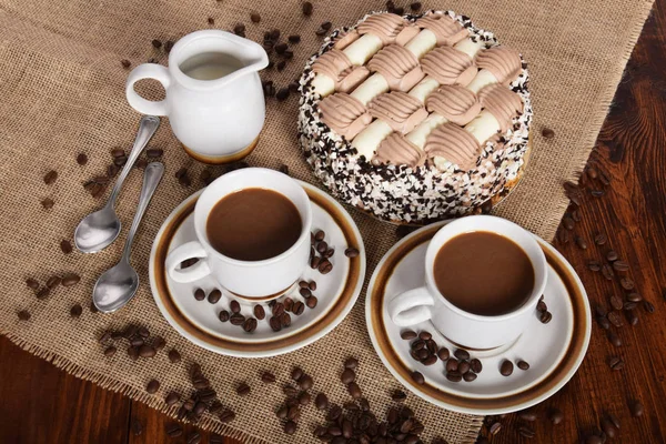 bardak kahve ve süt ve kavrulmuş kahve çekirdekleri