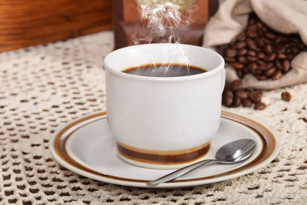 Café negro y pastel de café y un molinillo de café viejo — Foto de Stock