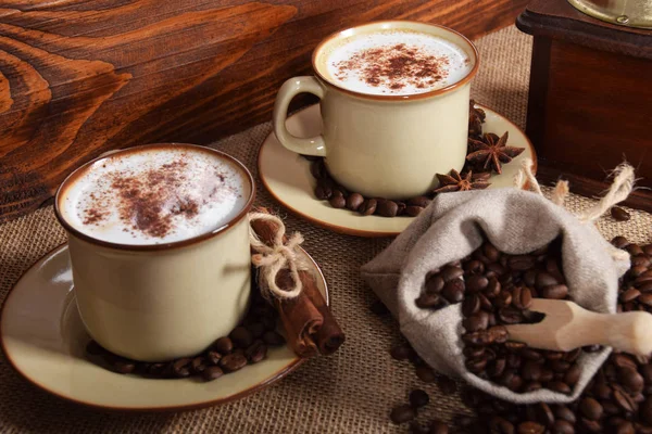 Café con leche y espuma de chocolate en tazas de cerámica marrón con v —  Fotos de Stock