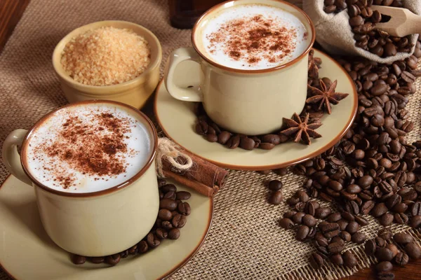 Café con leche y espuma de chocolate en tazas de cerámica marrón con v —  Fotos de Stock