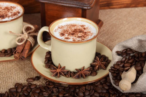 Café con leche y espuma de chocolate en tazas de cerámica marrón con v —  Fotos de Stock