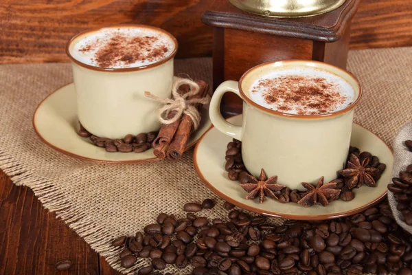 Café con leche y espuma de chocolate en tazas de cerámica marrón con v —  Fotos de Stock