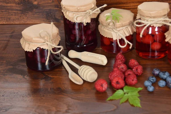 Blaubeeren und Himbeeren im Glas für den Wintertee mit Leergut — Stockfoto