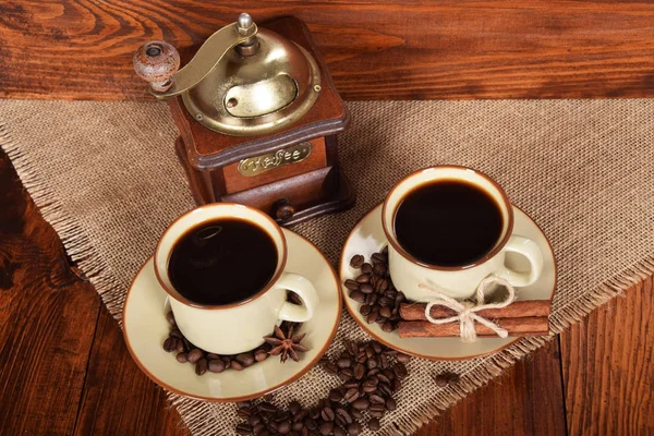 Duas xícaras de café preto ao lado de um moedor de café com pá livre — Fotografia de Stock