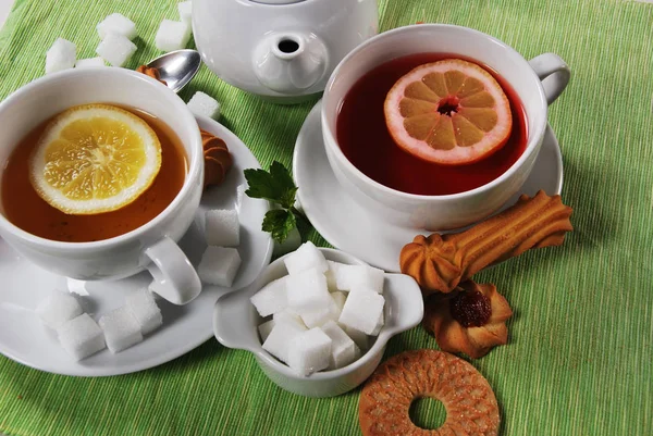 Grapefruit and lemon tea with sweet cookies and sugar cubes — Stock Photo, Image