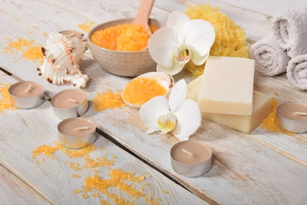 Оранжевая соль для ванн серые мыльные орхидеи и свечи — стоковое фото