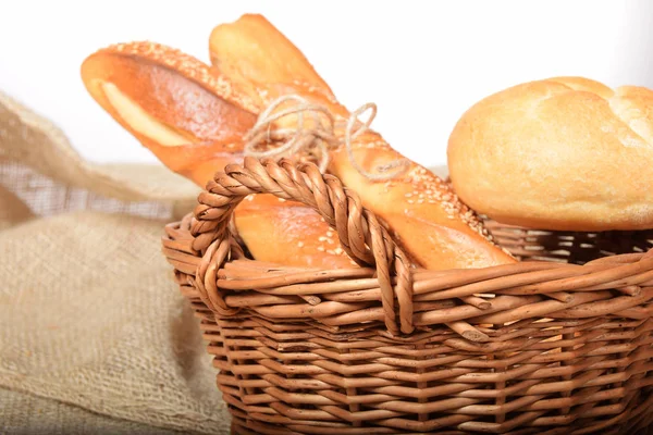 Un cestino di vimini pieno di panini caldi appena sfornati con semi di sesamo — Foto Stock