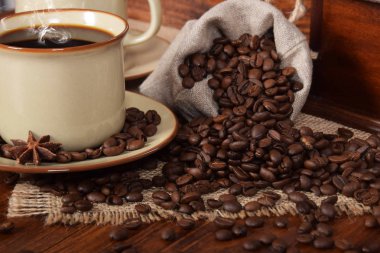 keten çanta dolusu kahve çekirdekleri bir bardak taze demlenmiş bl ile