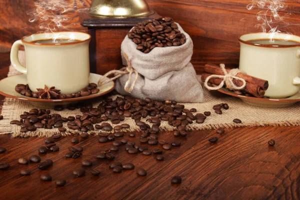 Una bolsa de lino llena de granos de café con una taza de bl recién hecho — Foto de Stock