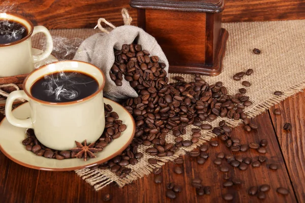 Eine Leinentasche voller Kaffeebohnen mit einer Tasse frisch gebrühtem Bl — Stockfoto