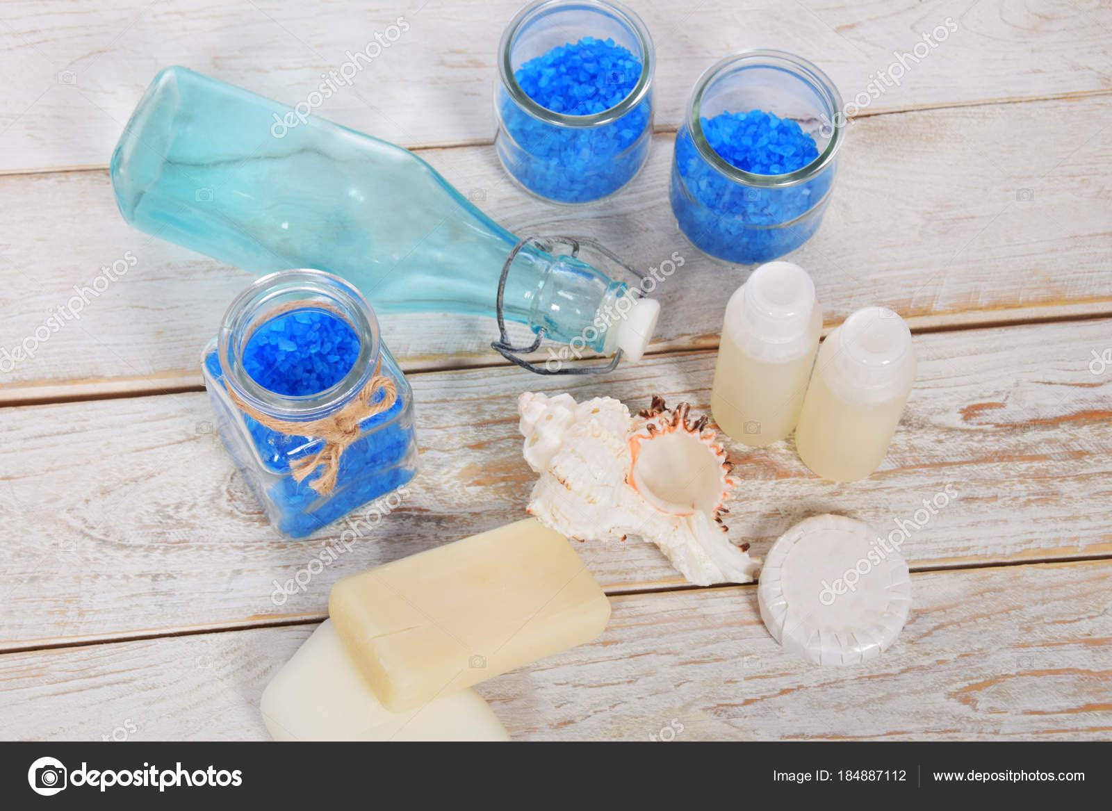 bottiglia di vetro azzurro con sale di bagno blu e conchiglie di ... bottiglia di vetro azzurro con sale di bagno blu e conchiglie di ...