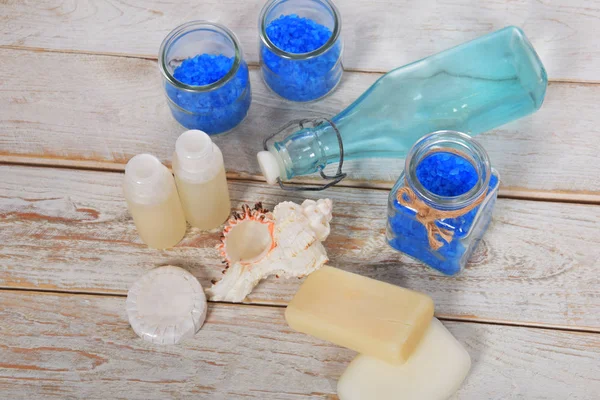 Garrafa de vidro azul claro com concha do mar e sal banho azul e mi — Fotografia de Stock