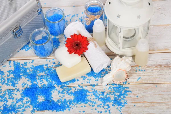 Flor de gerber rojo con sal marina azul para baño y mini champú a — Foto de Stock