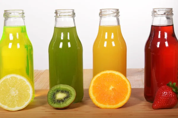 Flaska med färskpressad apelsinjuice med kiwi juice, jord — Stockfoto