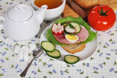 çiçek şeklindeki turp domates ve taze bir fincan sıcak çay rulo 