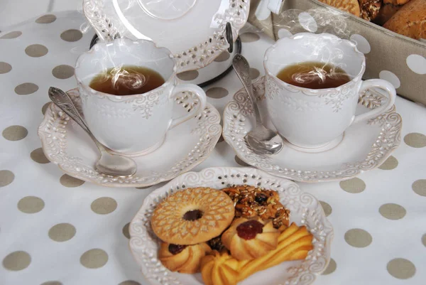 Deux tasses de thé chaud et une assiette rétro avec des biscuits sucrés avec va — Photo