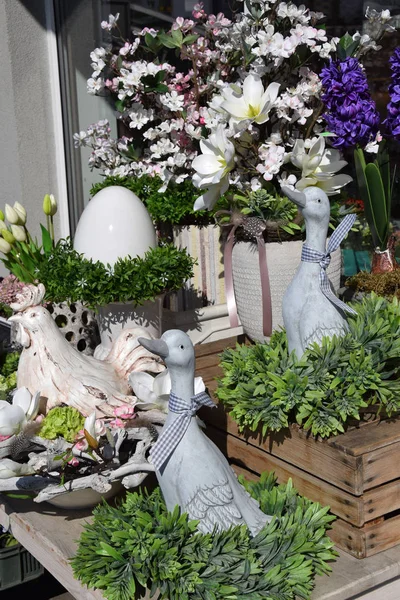 Graue Ente neben bunten Blumen, Osterdekoration — Stockfoto